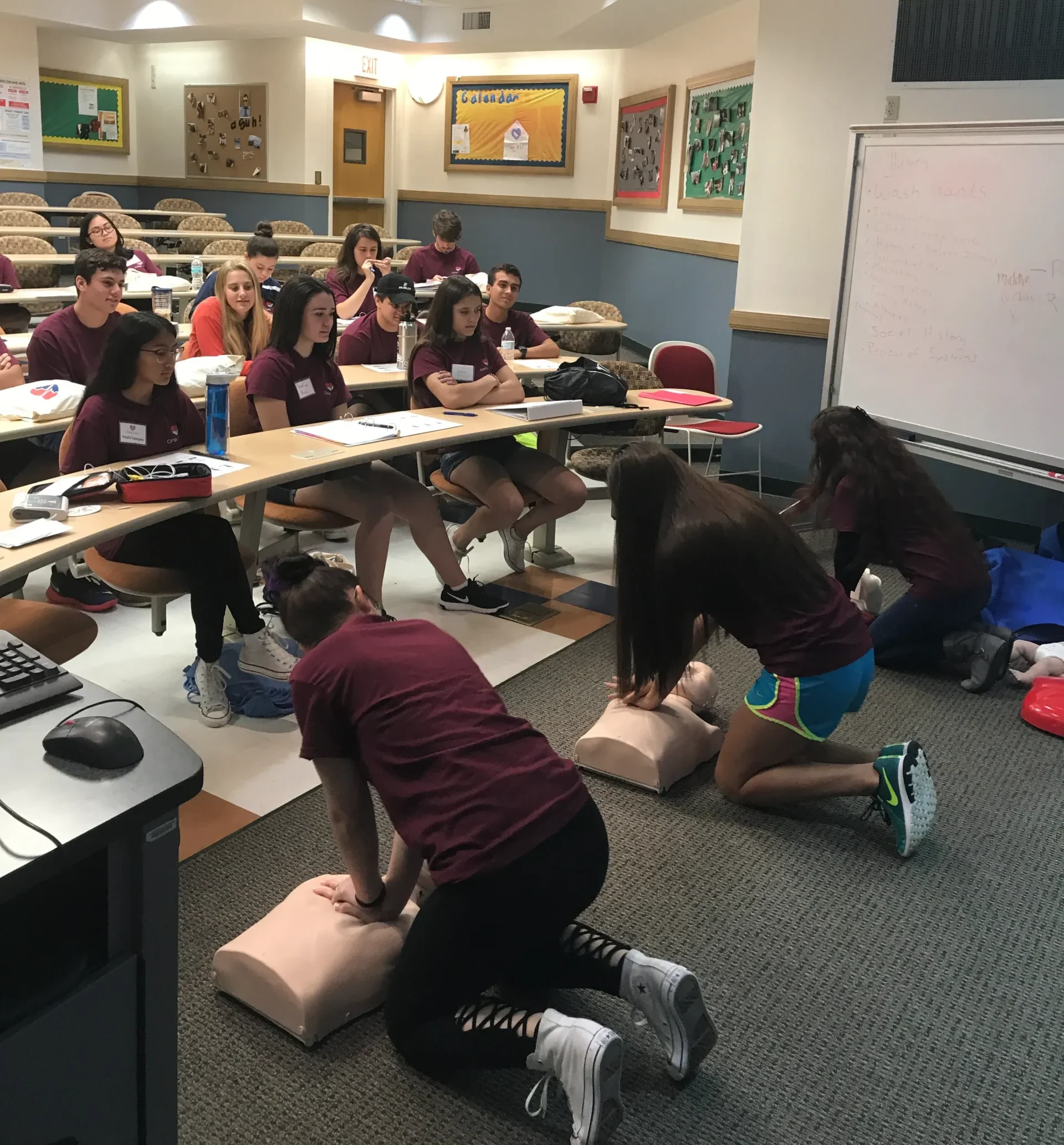 Students practicing CPR on mannequins during a classroom training sessions